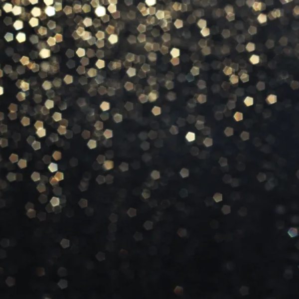 Black backdrop with falling gold bokeh lights
