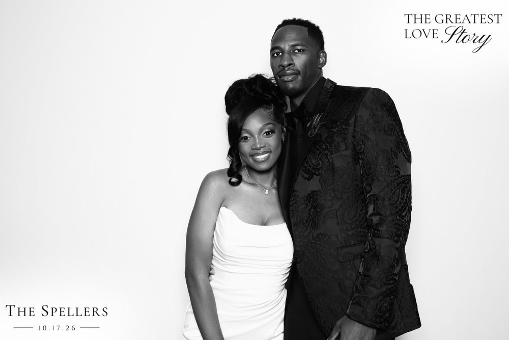 Newlyweds Makima and Trequan smiling together at their black-and-white wedding photo booth at the Signet Center in Chesapeake