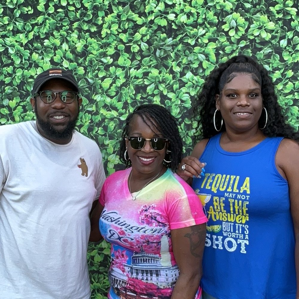 Three friends smiling together at an Easter family barbecue photo booth in Colerain, North Carolina