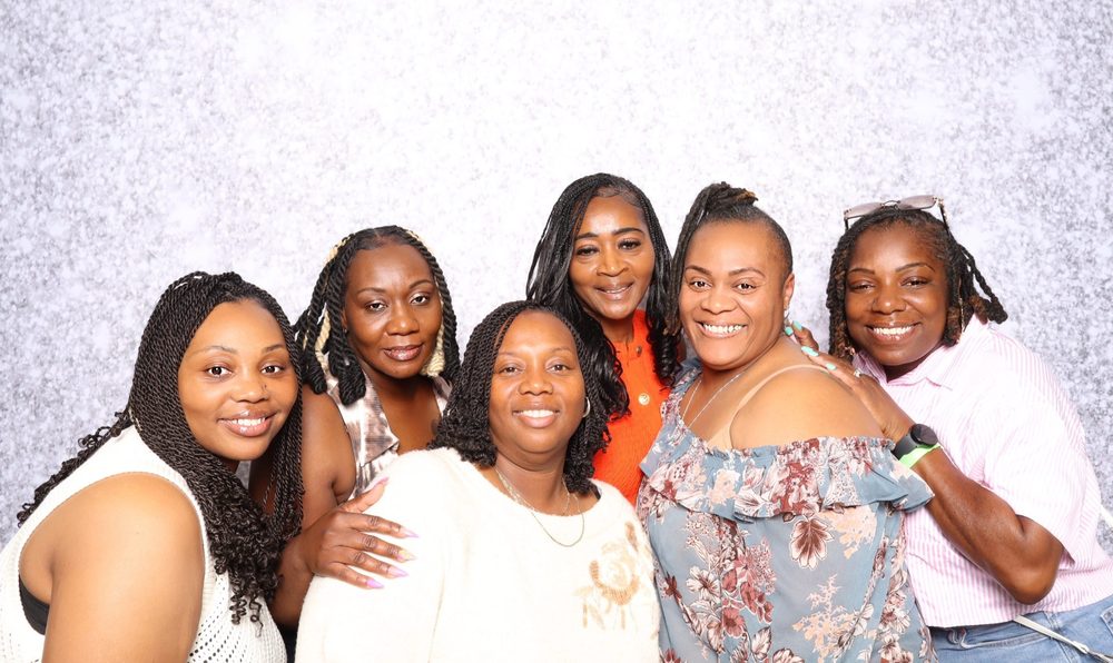 Six women smiling at a Beats on the Beach event photo booth in Virginia Beach