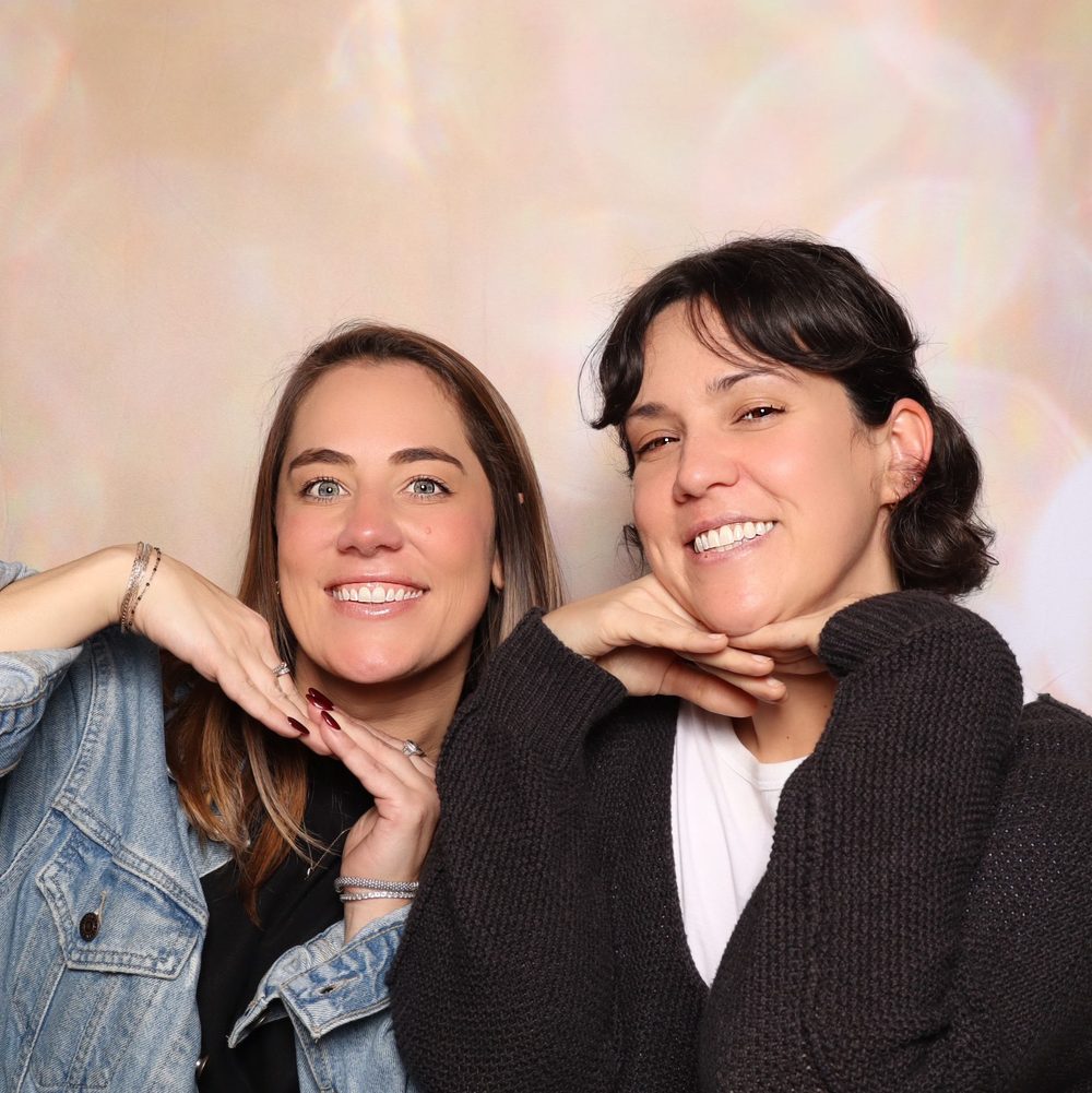 Two coworkers striking a pose at a corporate event photo booth in San Francisco