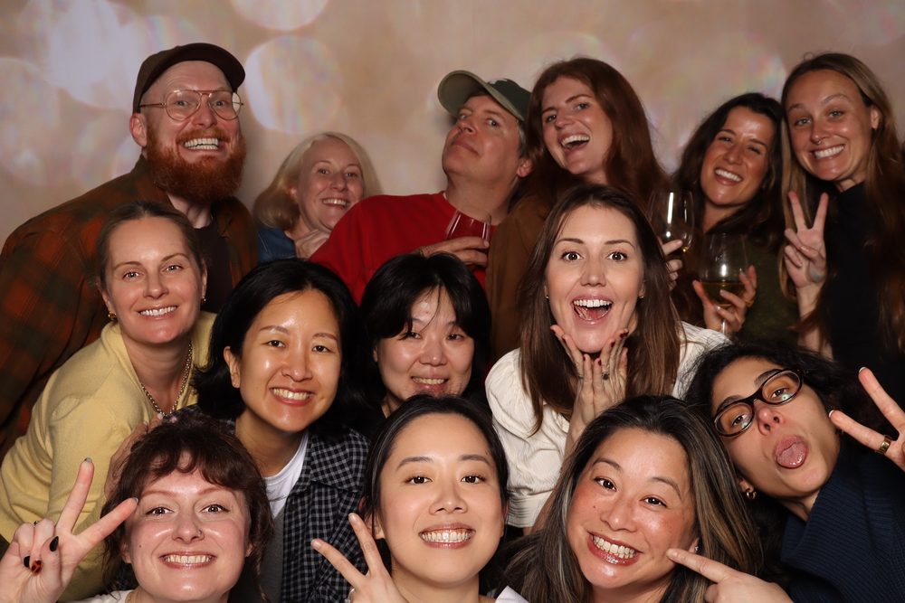 A large team throwing peace signs at a corporate offsite photo booth in San Francisco