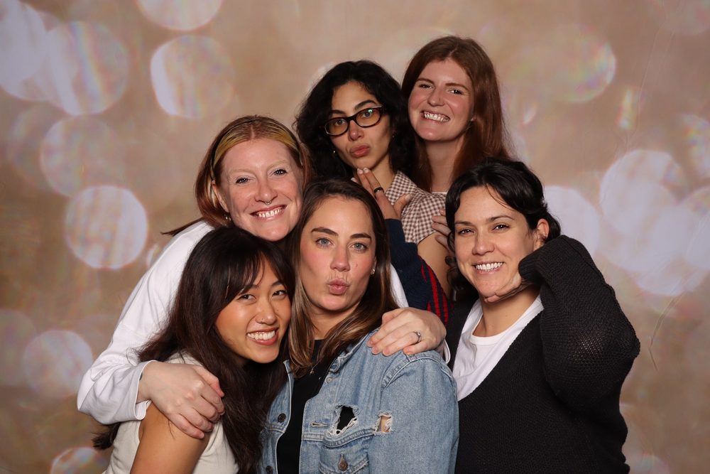 Coworkers laughing together at a corporate offsite photo booth in San Francisco