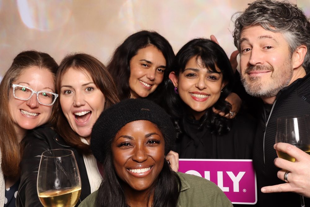 A group of coworkers laughing at a corporate event photo booth in San Francisco