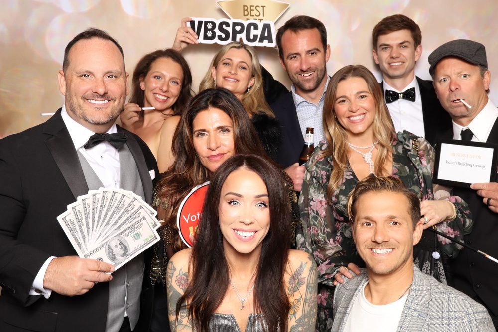 Gala guests with a VBSPCA sign at the Wags and Whiskers Gala photo booth in Virginia Beach