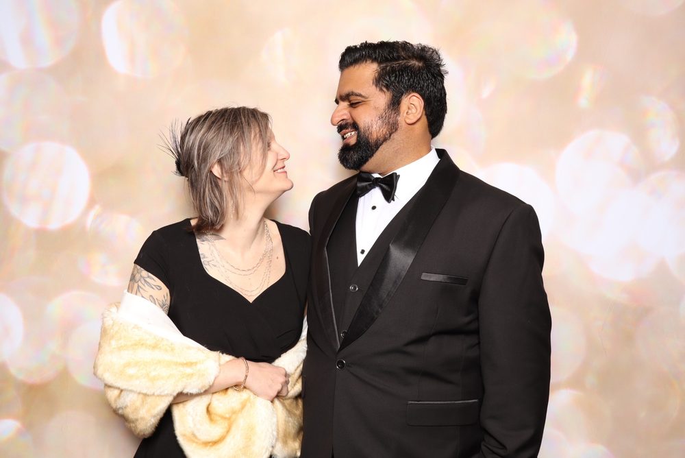 A couple in black tie at a charity gala photo booth in Virginia Beach
