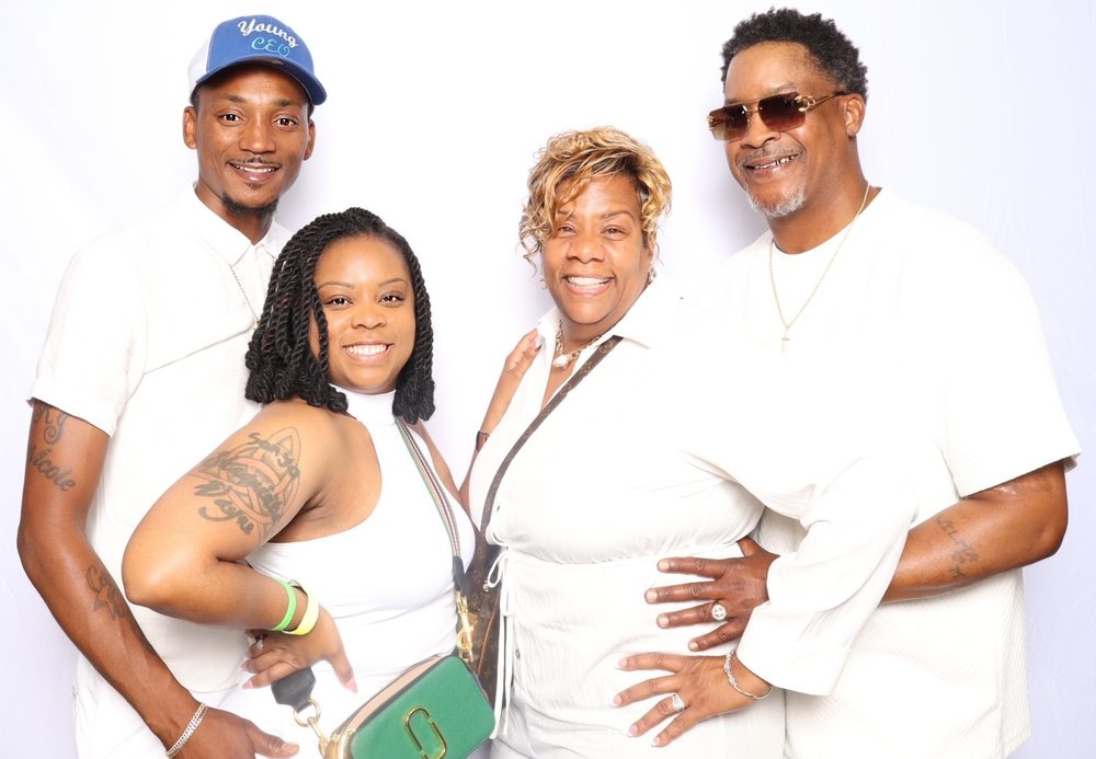 A family dressed in white smiling at an all-white party photo booth in Virginia Beach