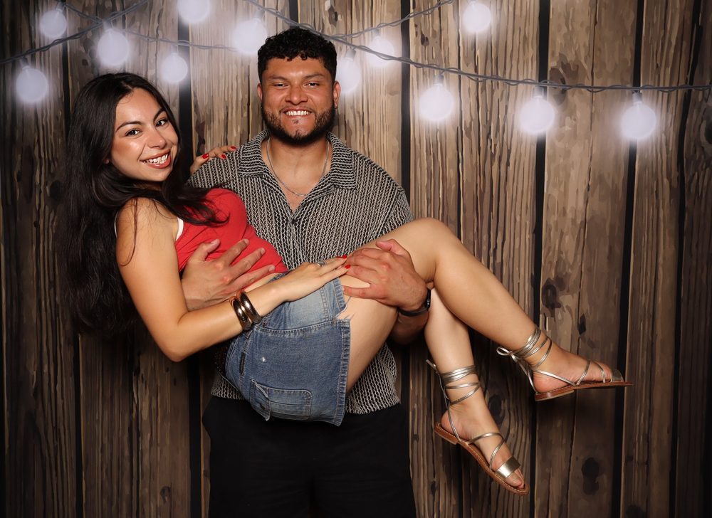 A guest scooping up his date at a Fourth of July party photo booth in Virginia Beach