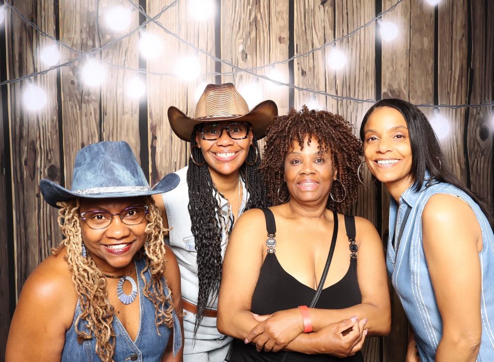 Friends in cowboy hats posing at a Southern soul party photo booth in Virginia Beach