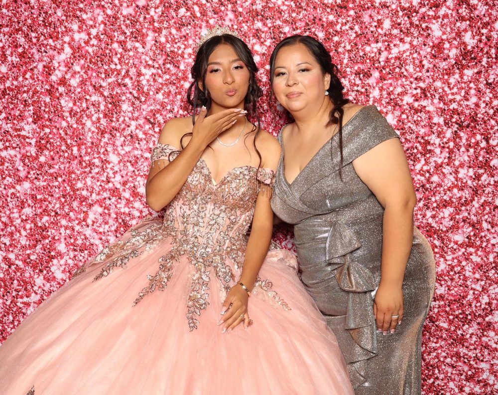A quinceañera blowing a kiss beside her mom at Lupita's quinceañera photo booth in Perth Amboy, New Jersey