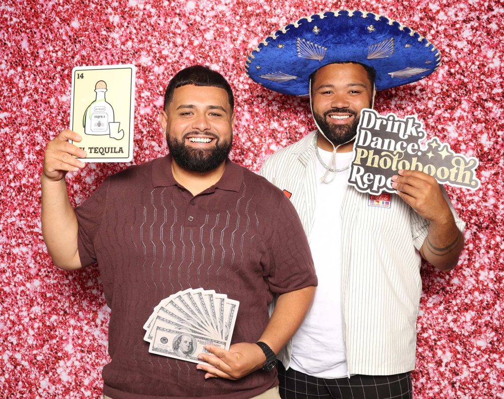 Two guests, one in a blue sombrero and one holding tequila and money fan props, at Lupita's quinceañera photo booth in Perth Amboy, New Jersey