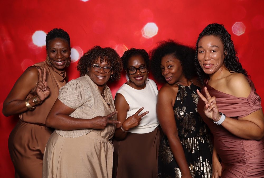 Five friends posing at a wedding reception photo booth in Suffolk