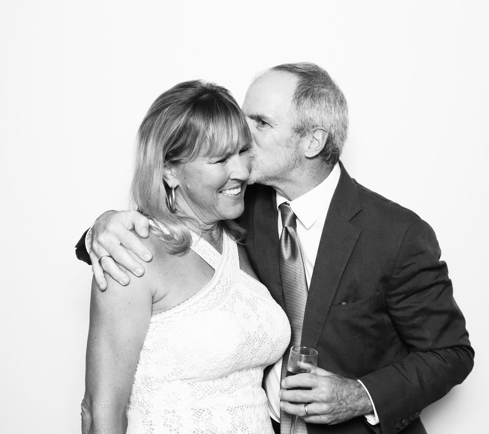 An older couple sharing a cheek kiss at a Virginia Beach wedding reception photo booth