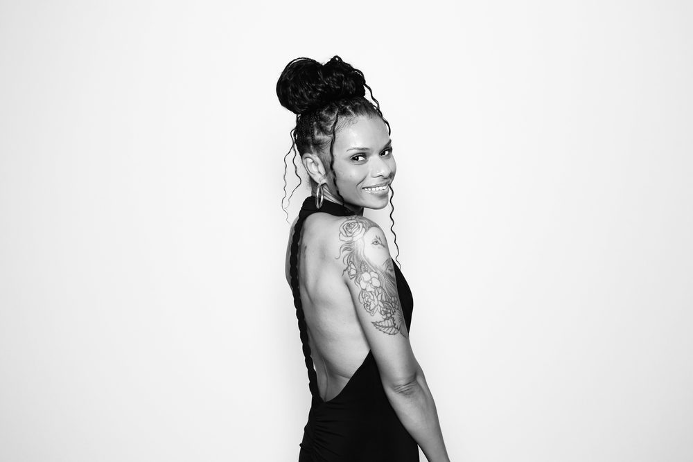A wedding guest in an open-back dress posing at an editorial photo booth in Chesapeake