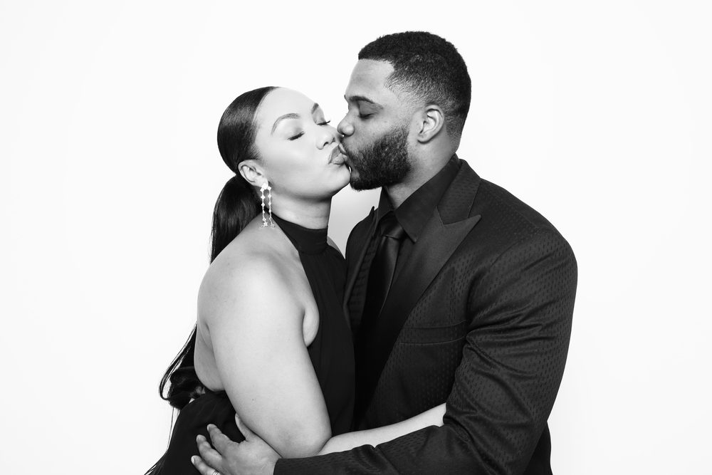 A guest couple sharing a cheek kiss at a Hampton wedding reception photo booth