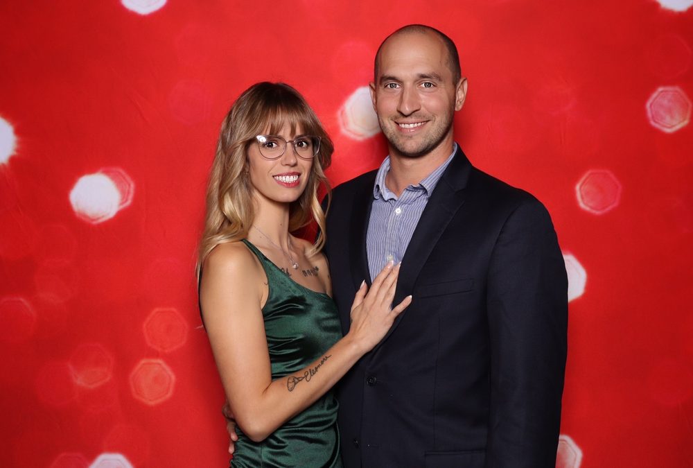 A guest couple posing at a wedding reception photo booth in Suffolk
