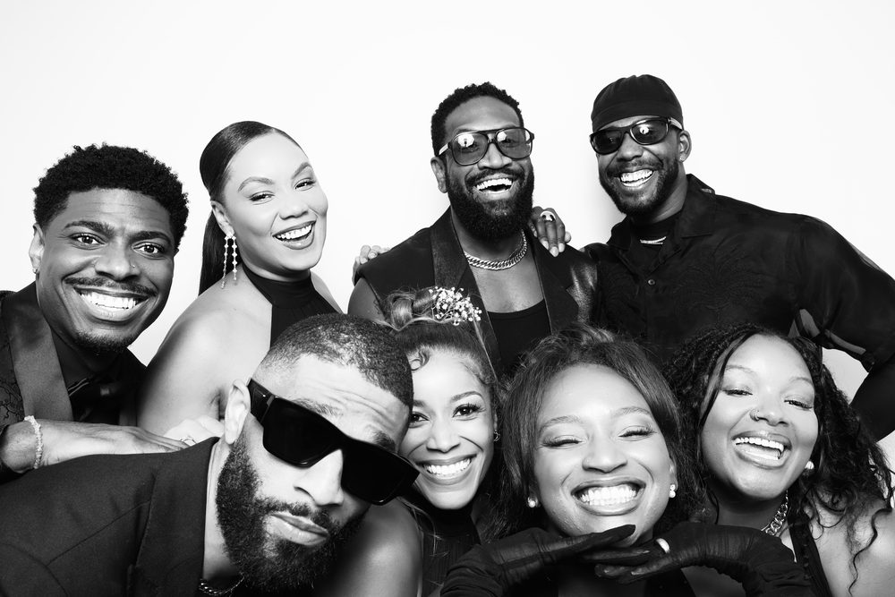 Wedding guests in sunglasses crowding into a black-and-white photo booth in Hampton