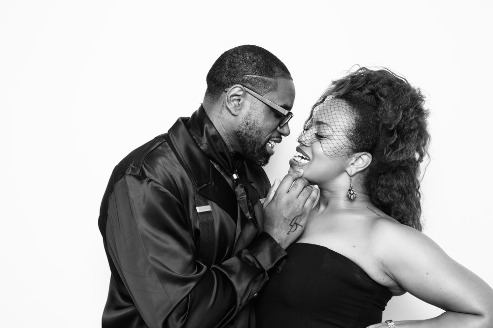 A guest couple leaning in for a kiss at a wedding photo booth in Hampton