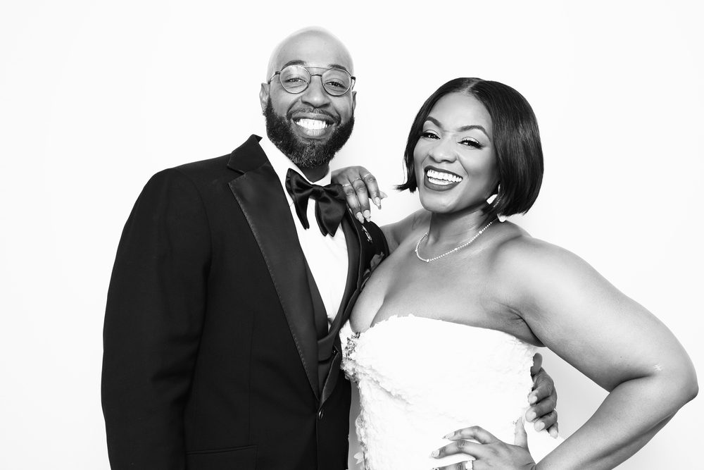 A smiling bride and groom at an editorial wedding photo booth in Hampton
