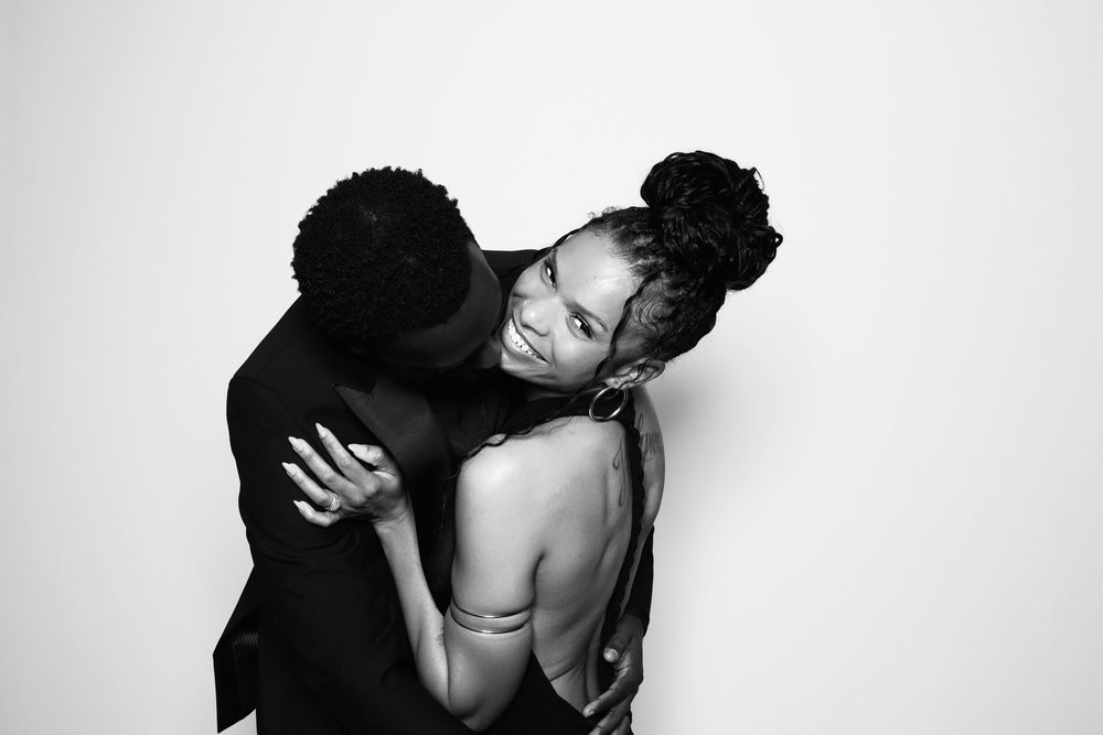 A couple laughing in an embrace at a Chesapeake wedding reception photo booth