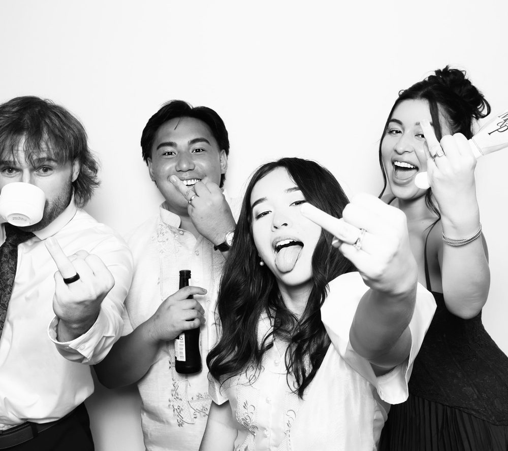 A bride showing off her ring with friends at a Virginia Beach wedding photo booth
