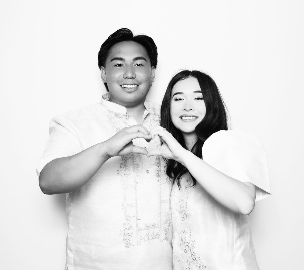 A bride and groom making a heart with their hands at a wedding photo booth in Virginia Beach