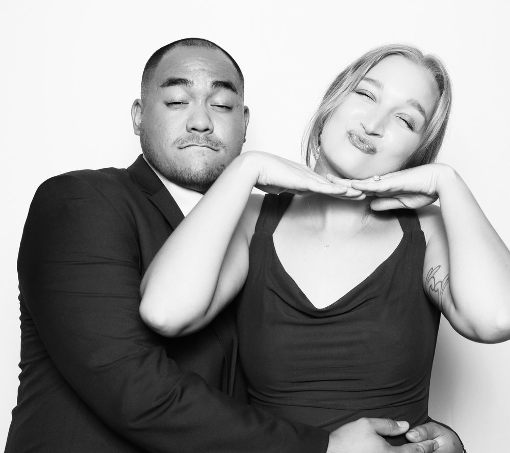 A guest couple striking a playful pose at a Virginia Beach wedding reception photo booth