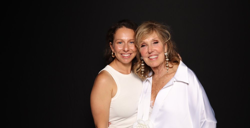 Two women in white smiling together at the FACT4Autism gala photo booth at The Dome in Virginia Beach